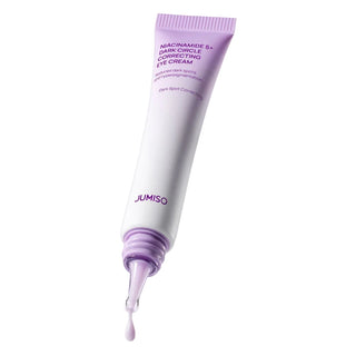 A squeeze tube of Jumiso Niacinamide 5+ Dark Circle Correcting Eye Cream, featuring a white body with lavender purple text and cap, with a small droplet of cream dripping from the tip against a clean white background.